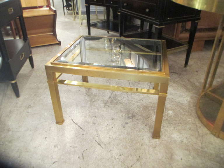 A pair of glass top bronze tables.