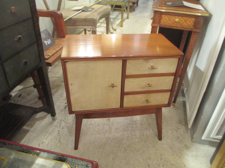 A pair of Italian Mid-Century Modern parchment nightstands with three drawers and a single cabinet door.