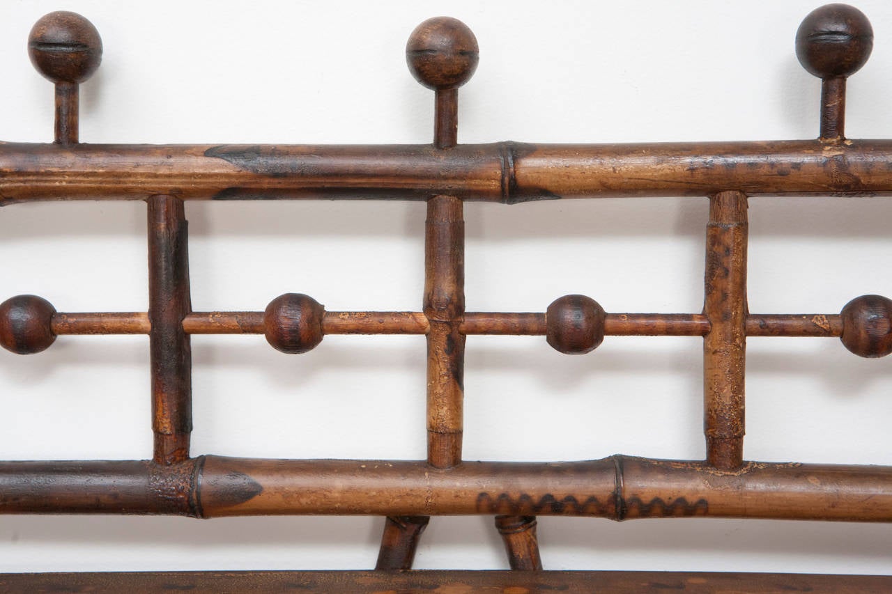 A good American stand in bamboo, circa 1890, having four wood shelves and turned ball finials. This wonderful piece of Victorian furniture has stick and ball features and burned designs throughout. This piece is a good size having four open shelves.