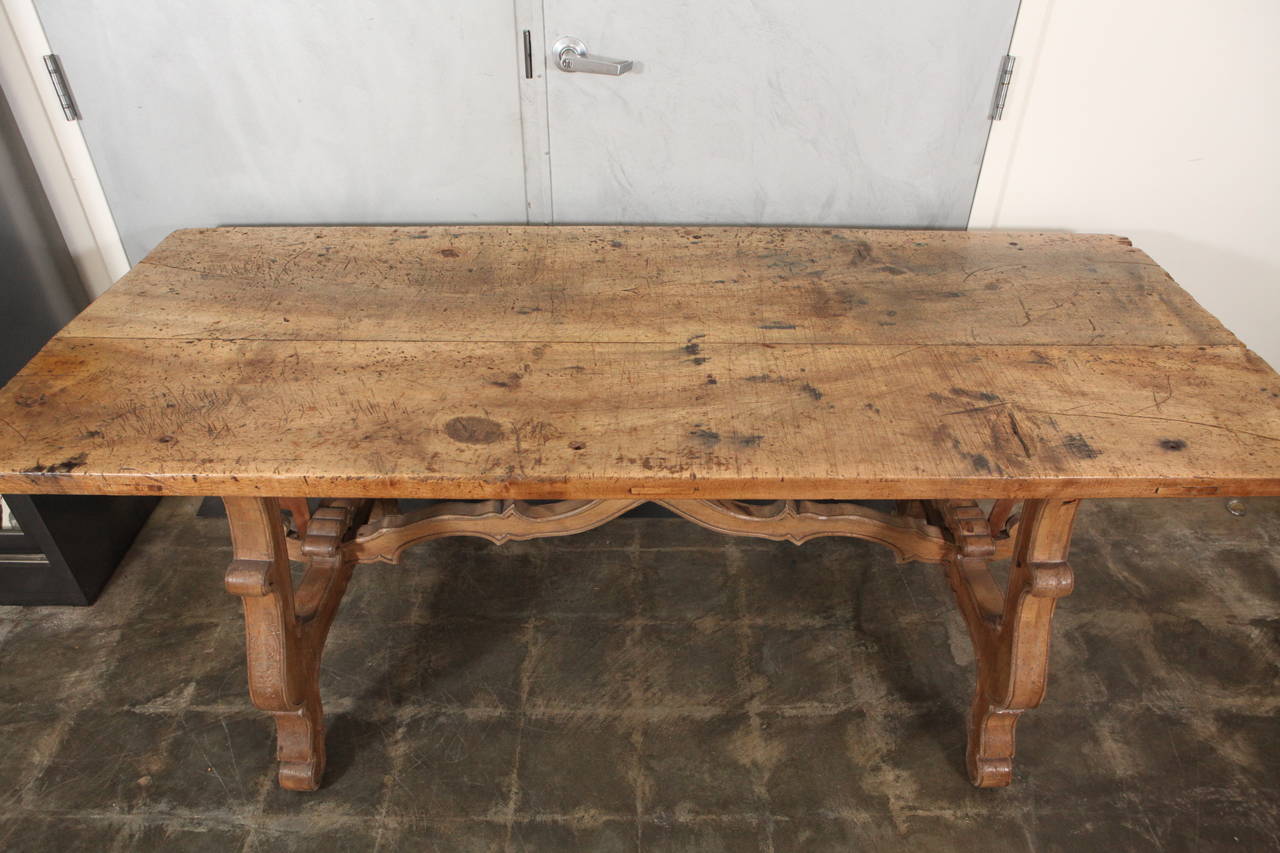 This beautiful table has an original 19th century walnut tabletop and carved legs with carved stretcher bar and shaped fittings that look to be made at a later date, most likely in the early 20th century.