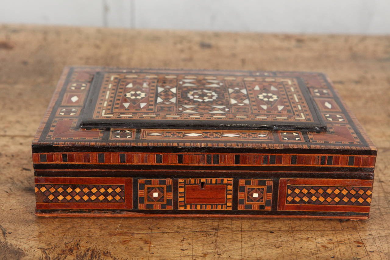 Antique Syrian box inlaid with exquisite wood and mother of pearl marquetry techniques including a nice little piece of decorative marquetry on the interior of the lid. This piece is a great example of very fine, handcrafted Moorish micro mosaic
