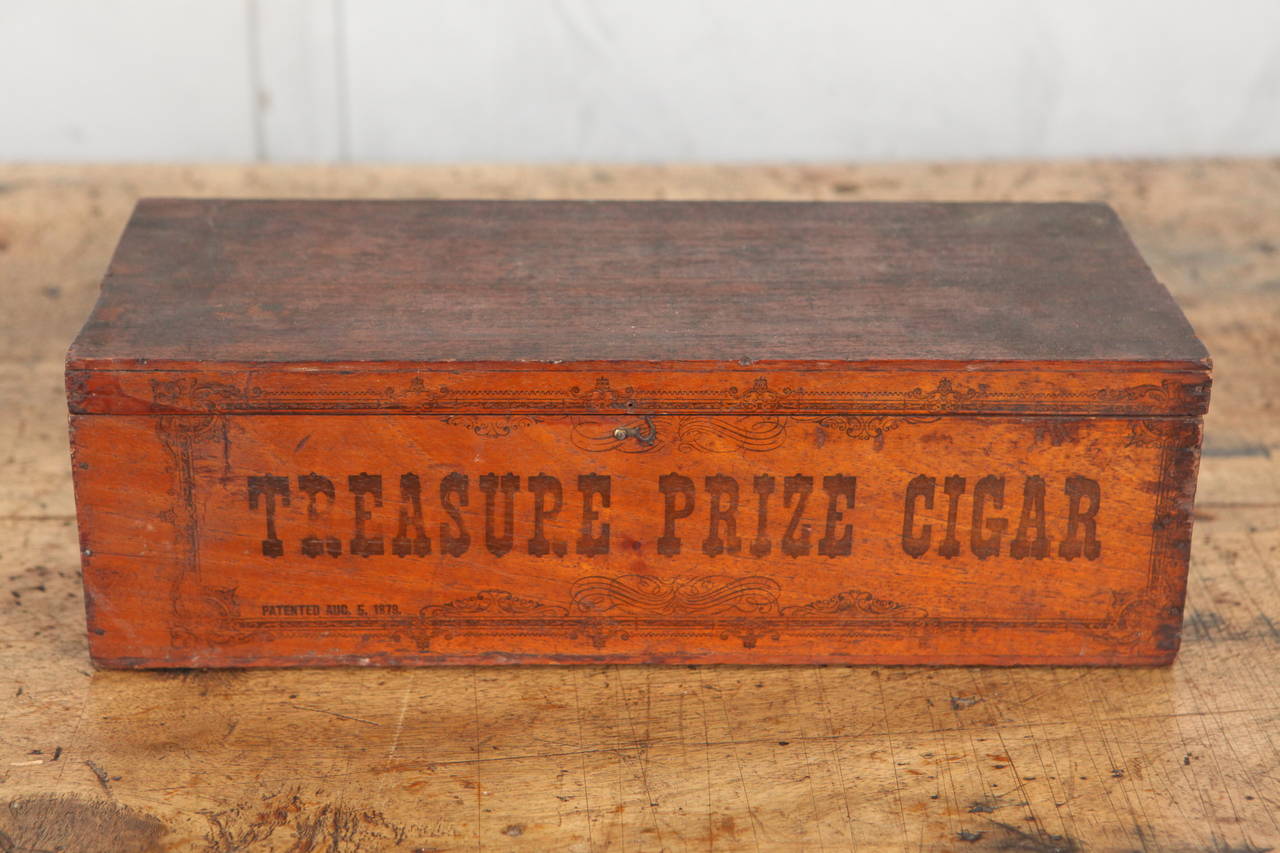 This wonderful cigar box seems to have been used in a shop as a display for cigars. The box is covered in delightful phrases and decorative details. The original paper label is on the inside.  There is printing on the outside of the box faded with