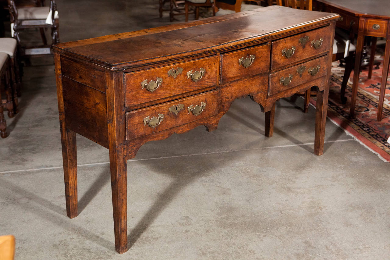 A great example of an 18th century Oak Dresser base. Has five drawers with nicely shaped brass drawer pulls and escutcheons.