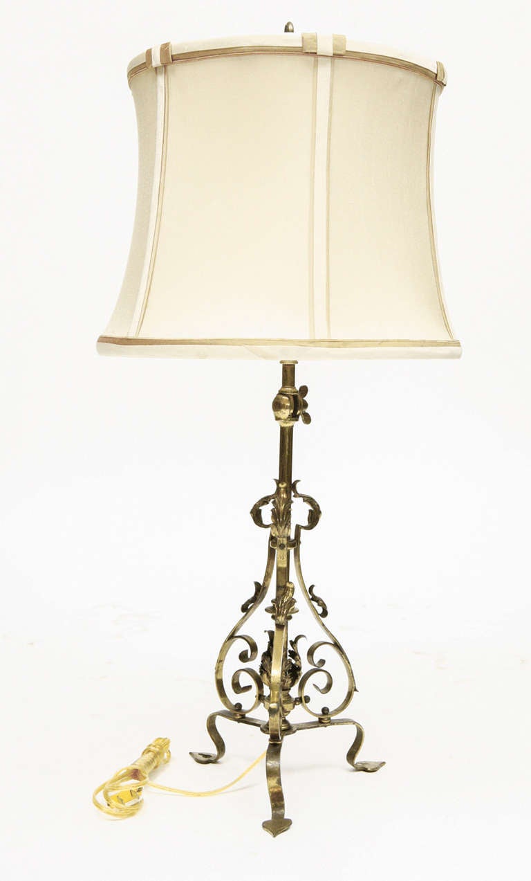 This lamp is unusual in that it may be used as a wall or table lamp. The body of the lamp is hand wrought brass standing on three legs. There is a element that may be turned to an angle for mounting the lamp to the wall if desired.
