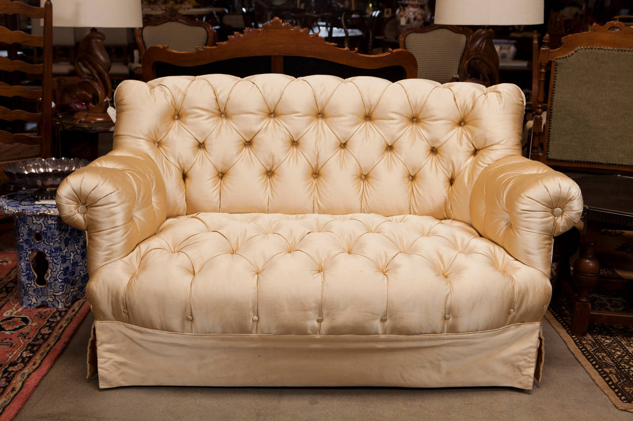 This classic Victorian button tuft settee has been previously upholstered in a luxurious Ivory Satin.