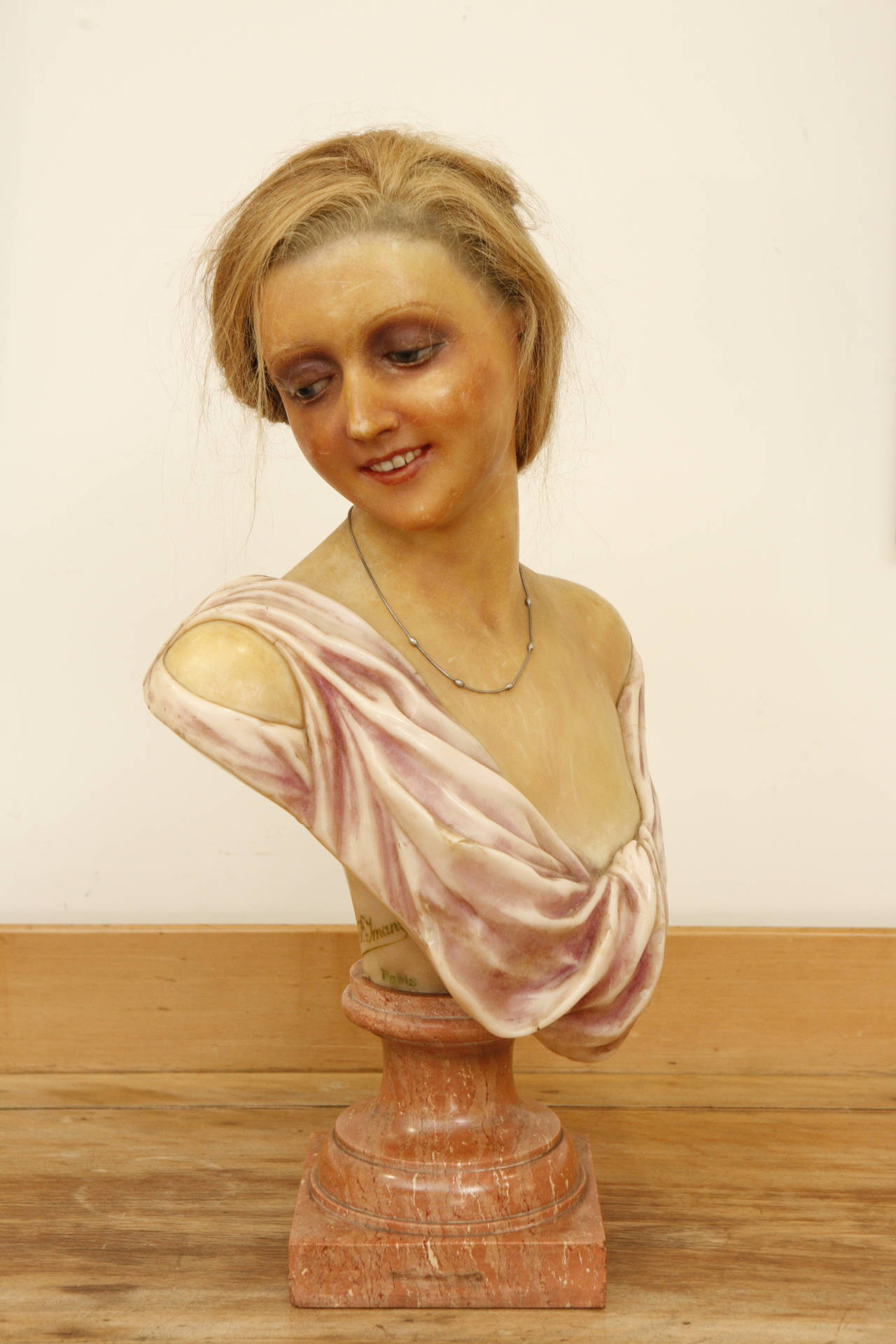This is very rare and charming female bust with the signature of Pierre Imans, the premier parisan mannequin maker of the 20th century. The mannequin sits on a marble swivel pedestal. Extremely life-like, the style of the dress is typical of the