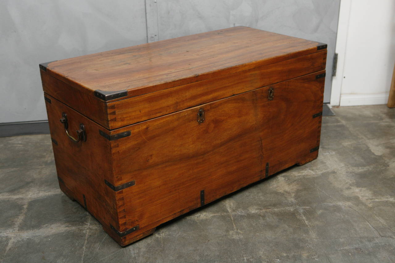The trunk is made of camphor wood which has a wonderful aroma. The piece has side carrying handles, 22 brass brackets, hinges, two locks and is raised on pad feet.
