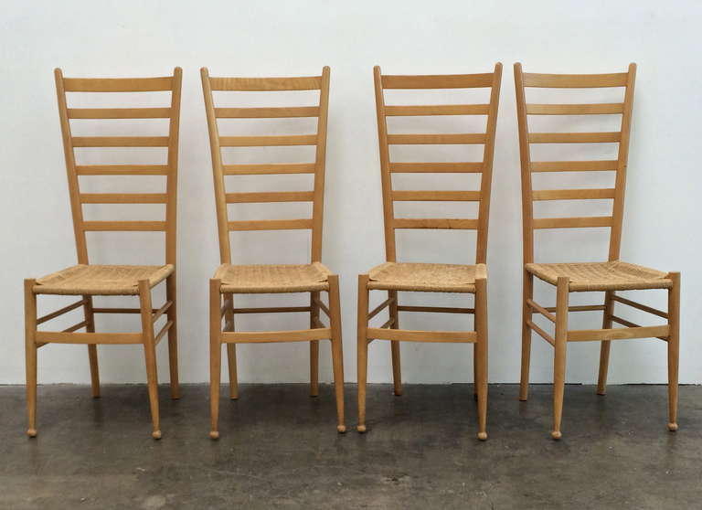 Set of four ladder-back chairs in the style of Gio Ponti, circa 1970s.
Wood, with woven seats. 
Height: 42
