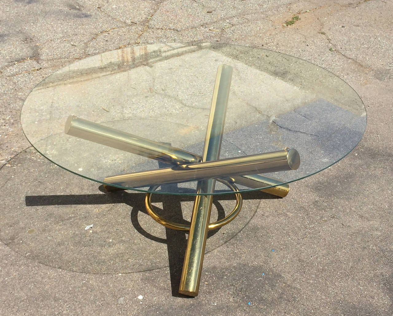 Jax-Shaped Cofffee Tables
Circa 1970s
Brass-plated metal, glass top
22 inches high, 36 inches in diameter
Overall good condition. Minor scratches to glass, some wear to base.