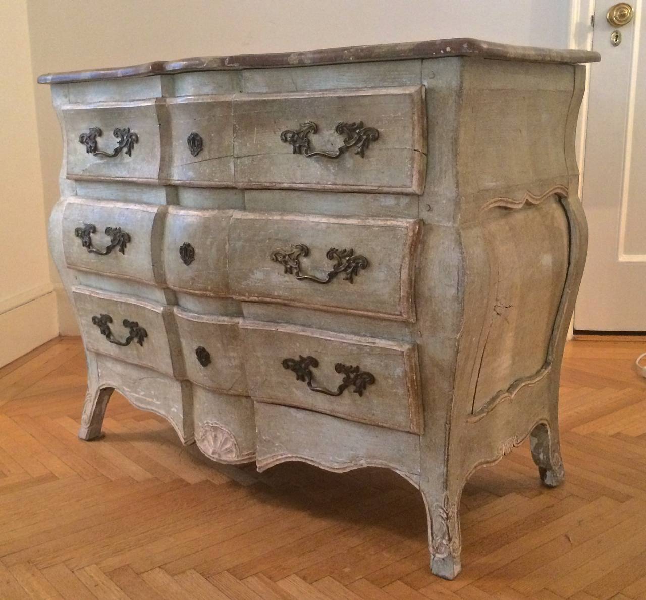 Louis XV Commode en Tombeau
France
18th century
Red and white serpentine faux-painted wood top; pale green painted bombe-shaped body; three paneled drawers and a conformingly-shaped apron; the whole form is raised on short stylized “pied de