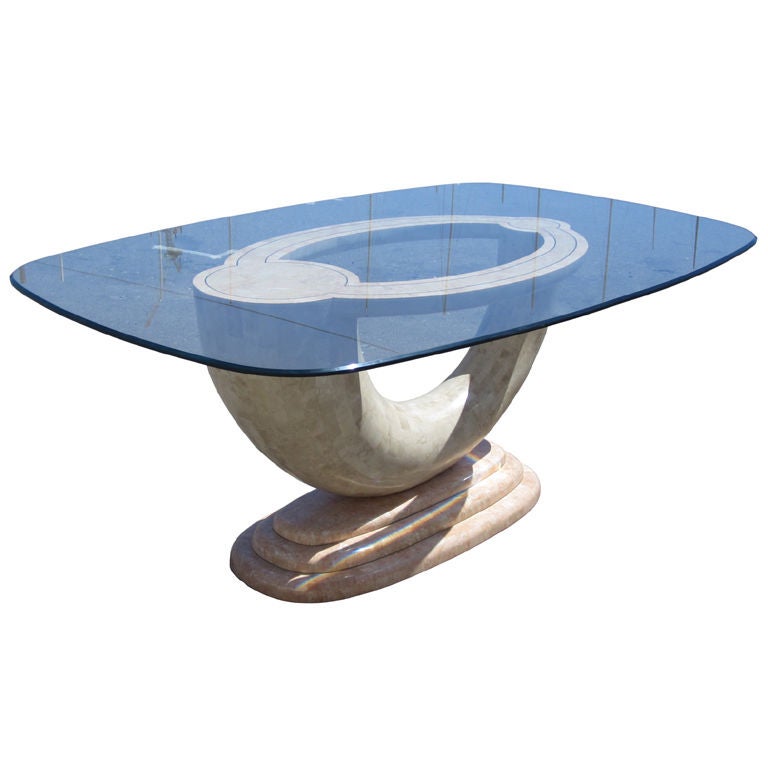 Dining/conference table by Maitland Smith. One of their more abstract, visionary designs. Horn-inspired form in tesselated stone, pinks, whites and beige with brass inlay and glass top.