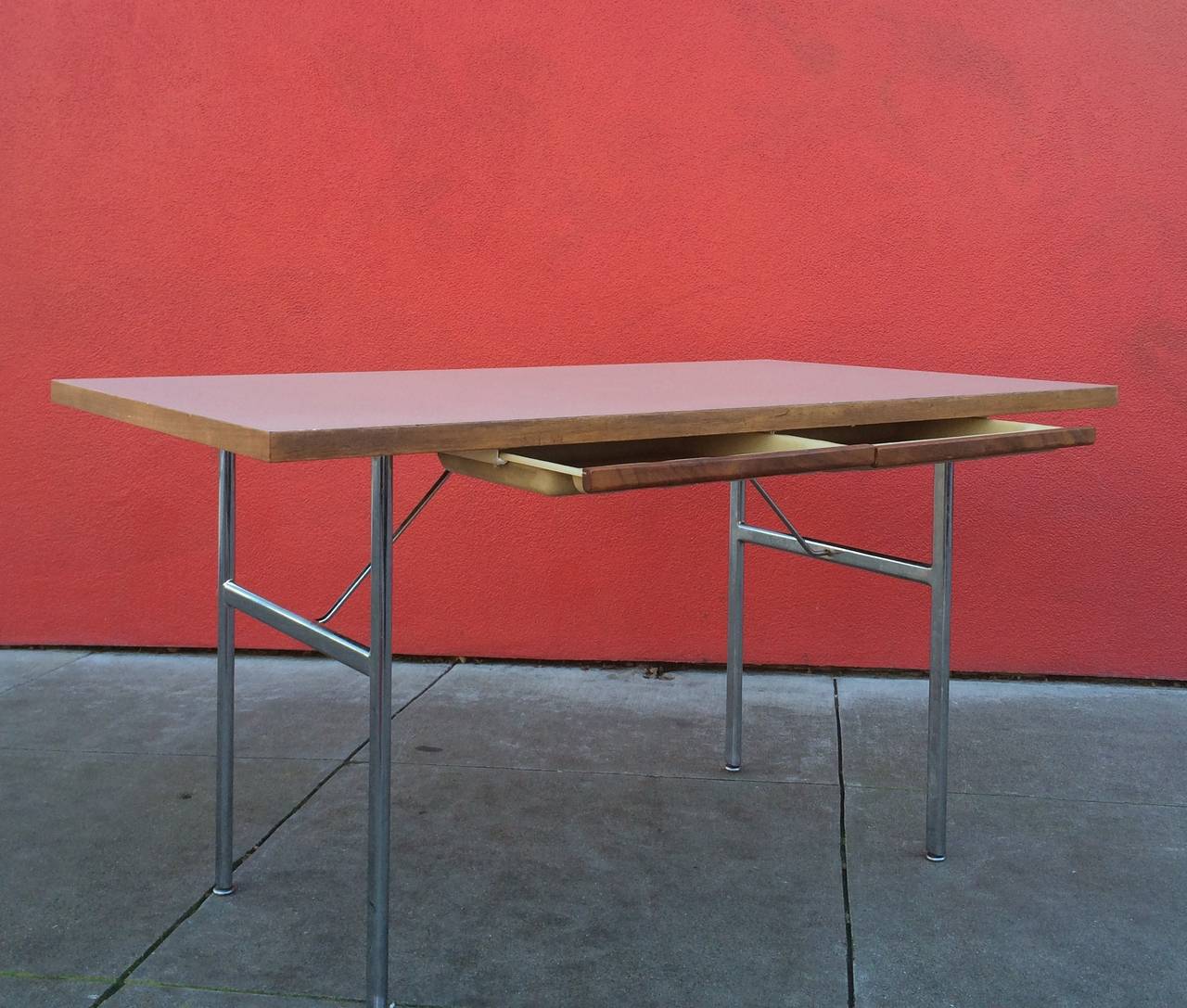 George Nelson.
Desk with Drawers
Circa 1955.
Laminate top, walnut vener edges, chrome legs and struts, removable molded plastic drawers with walnut veneer.
Measures: 52.5 x 32 x 29 inches.
Manufactured by Herman Miller.
Very good condition