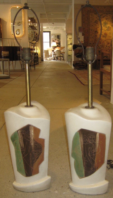 Scuptural white bisque lamps with sgraffito figural design and tri-band of earthtone glazes. Paper labels to each example.