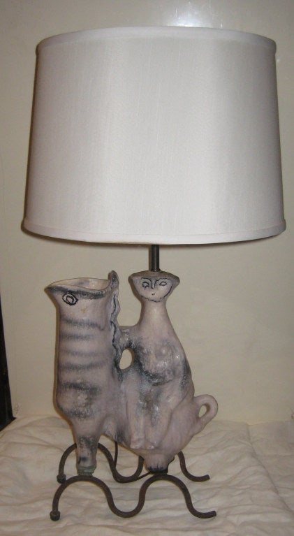 Wonderful, whimsical hand-thrown pottery lamp of a woman on a llama in cream and dripped blue glaze, on a wrought iron base. Pottery was designed as a lamp base, with llama doubling as a vase.