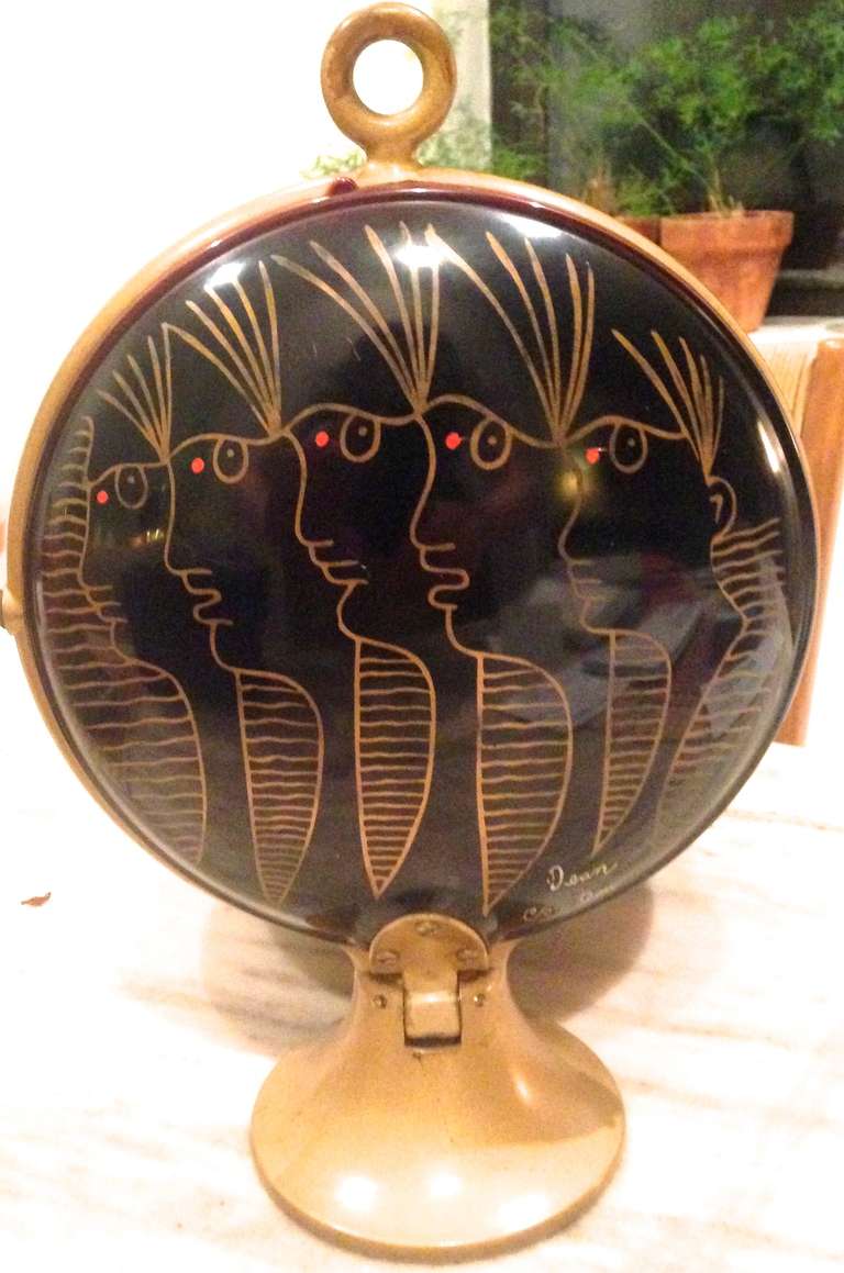 Hand-painted melamine serving bowls bearing five stylized faces in profile, designed by Jean Cocteau, mounted to a hinged brass frame. Folds up to be displayed, and folds down into a two-tier server.  Signed Jean Cocteau