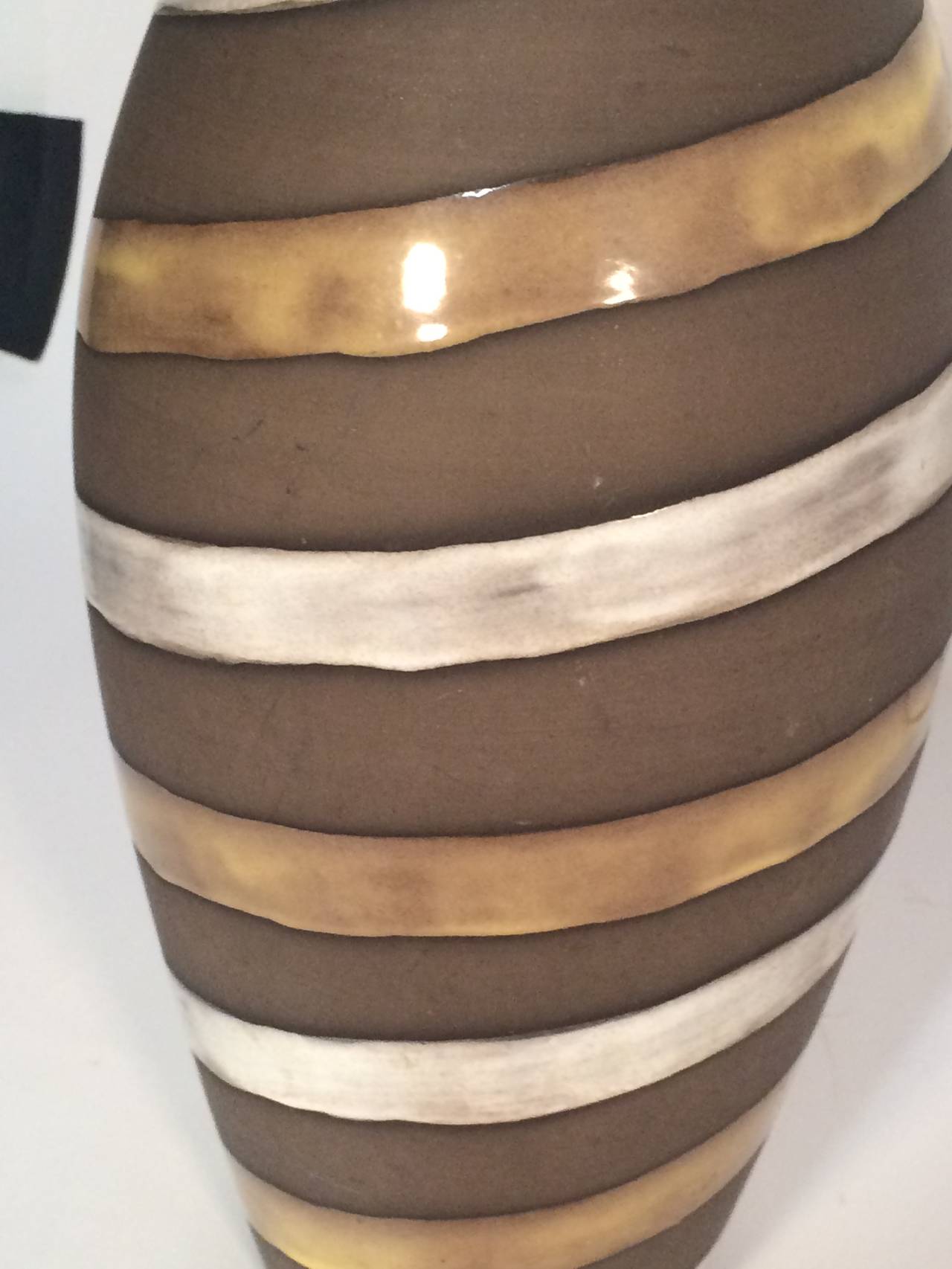 Glossy gold-brown and white twisting stripes over matte brown glazed base. Made as lamps.