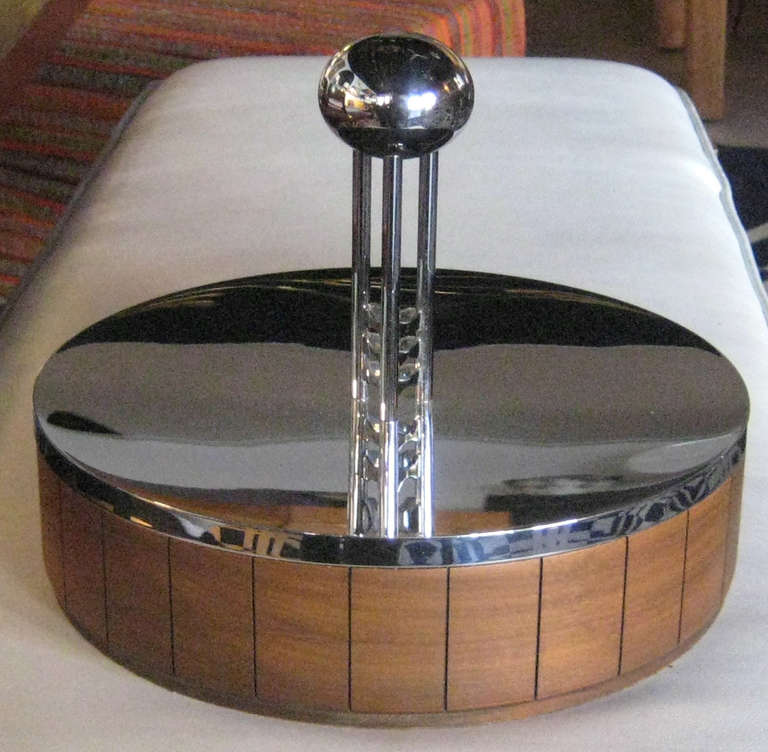 Heavy mirror-finish chrome lid is scale model of Saarinen's GM Tech tower, over carved walnut case. The composition of the box wonderfully demonstrates the connection between the younger Saarinen's reduced modernism with the decorative nouveau of