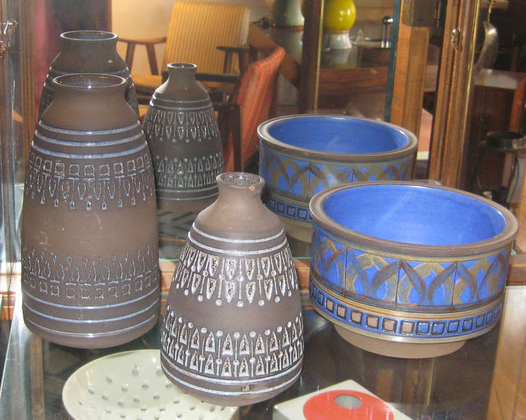 Simple, rustic stoneware pottery still showcases Wiinblad's taste for the Arabesque. Hand incised signature to the bottom of each piece. Small vase is 6