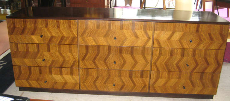 Wonderful and rare early design by Baughman for the Directional Furniture Company.  Dark Mahogany case with nine drawers in an intricate zig zag design from walnut, mahogany, and rosewood veneers.  The metal tag dates this to 1952 or 1953.