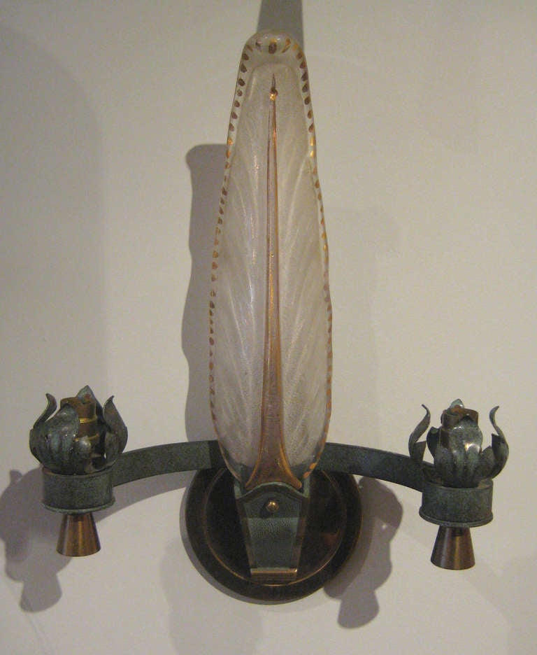 Set of three two-arm sconces with verdigris scroll and leaf cups, bronze hardware, and large glass plume with gold inclusion.