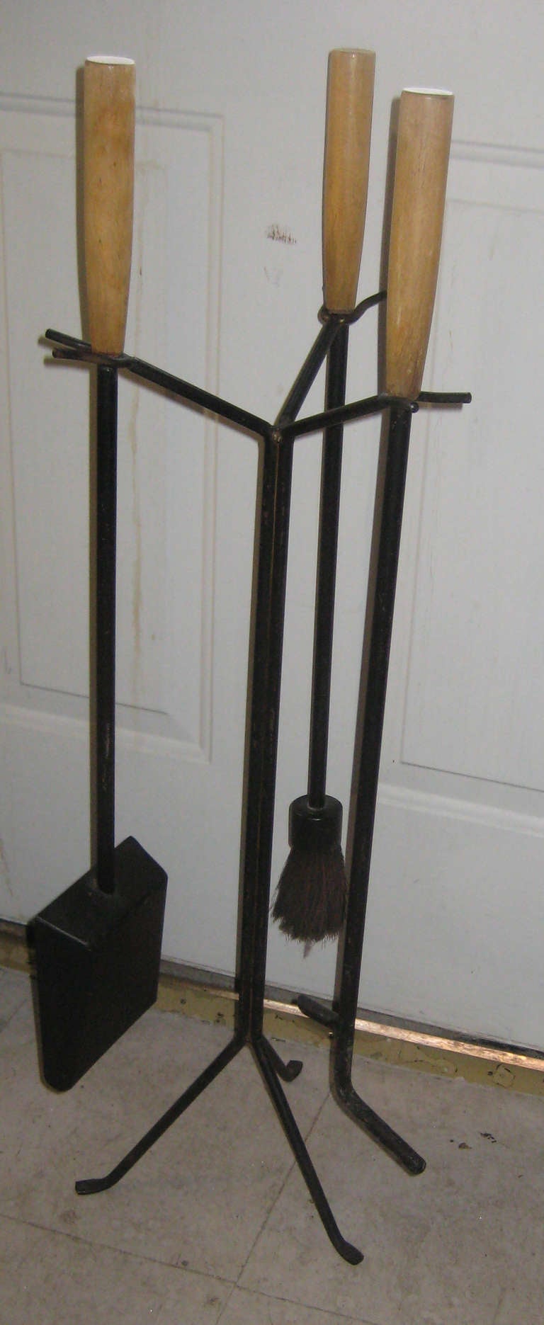 Rare and iconic painted iron and birch fireplace tool set designed by George Nelson for the Howard Miller Company. Includes stand, brush, shovel, and poker.