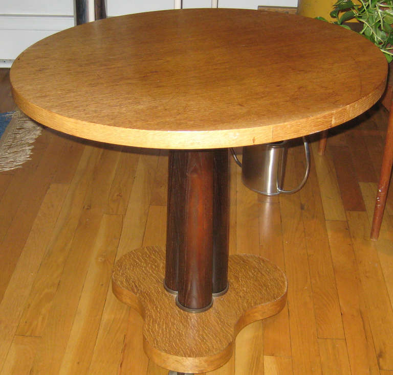 Lovely oval tri-column pedestal table in natural and stained English oak with bronze raised feet. Signed with Dunbar gold tag and paper label.