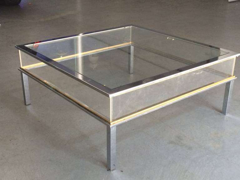 Chic 1970s Italian chrome table with brass accents glass top and perspex sides.  The top slides to access interior display case.