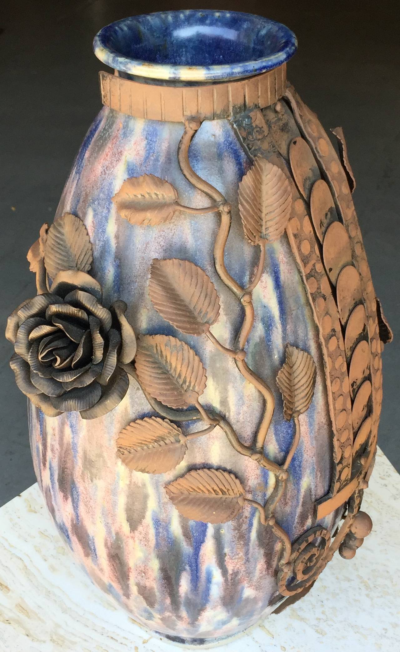 Large hand thrown pottery vase by Roger Guerin with subtle poly-chromatic glaze, with elaborate hand-chased wrought iron applique´ by Franc¸ois Carion. Signed on bottom.