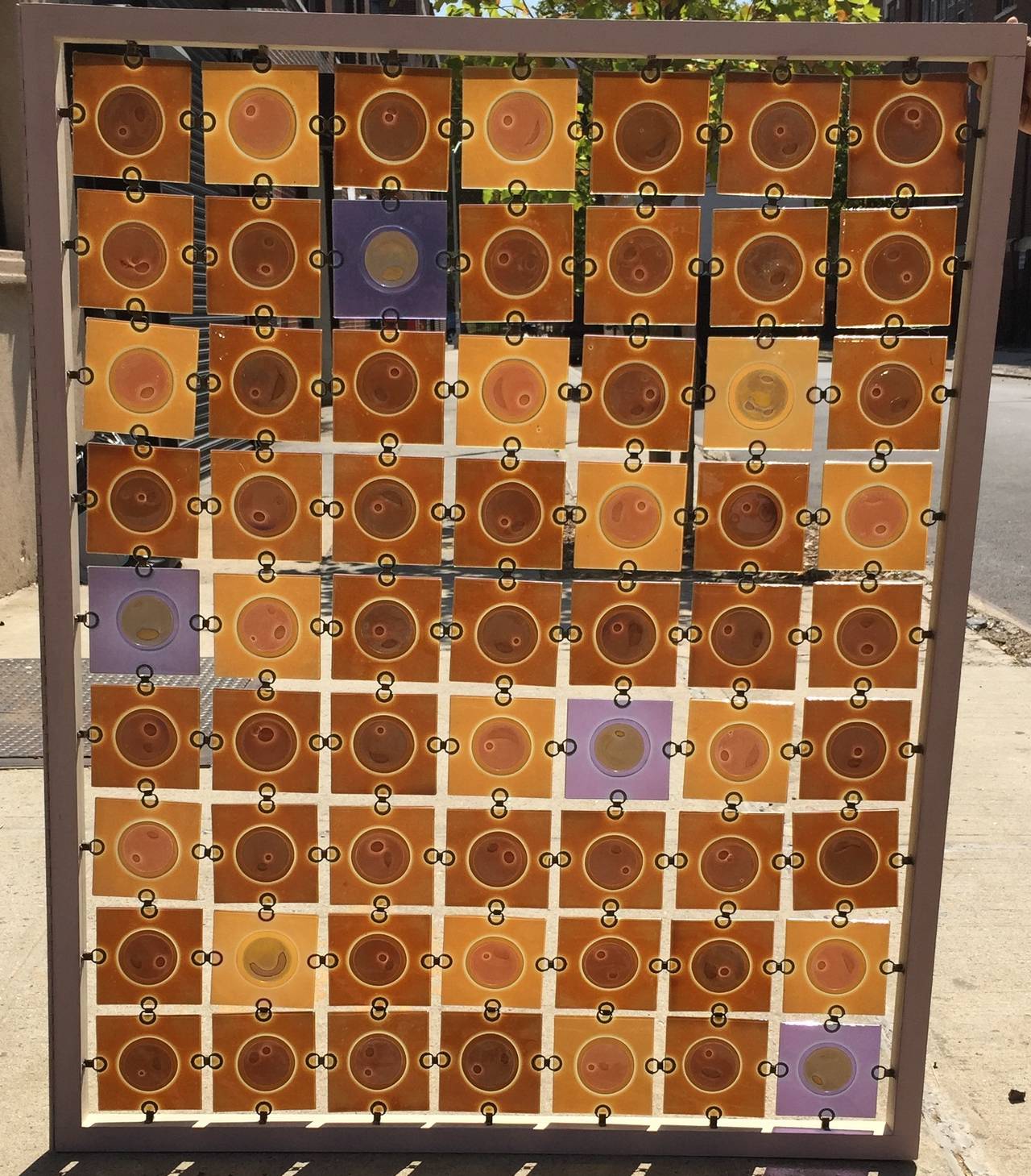 Rare five-color glass panel screen in wood frame by Michael and Frances Higgins. Great modern design in neutral brown, orange and yellow tones, with bursts of blue and purple. 63 glass panels per screen. 

If removed from wood frame the glass can be