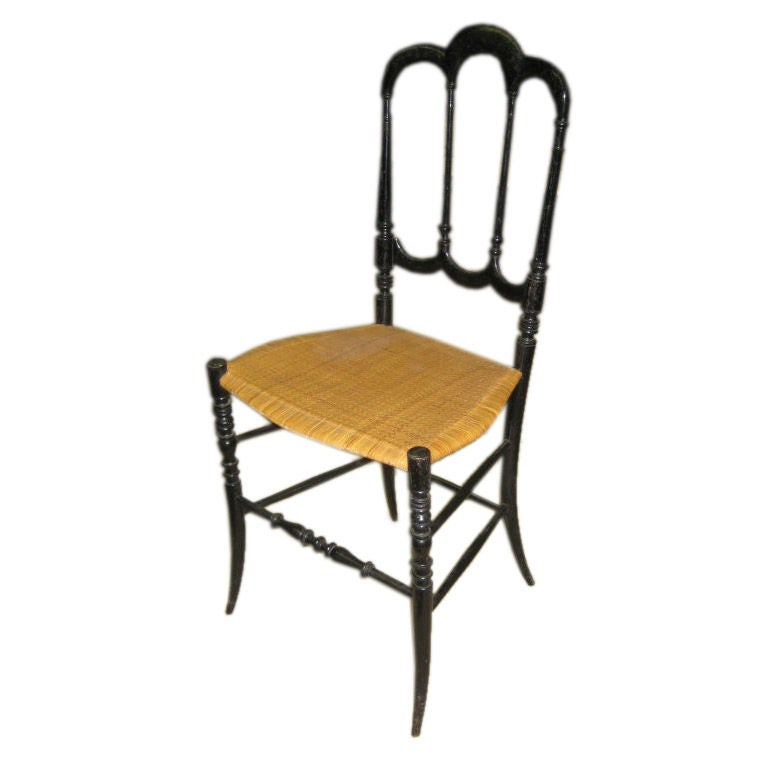 Carved and ebonized fruitwood chairs with beautiful, original cane seat. Old paper label to underside.