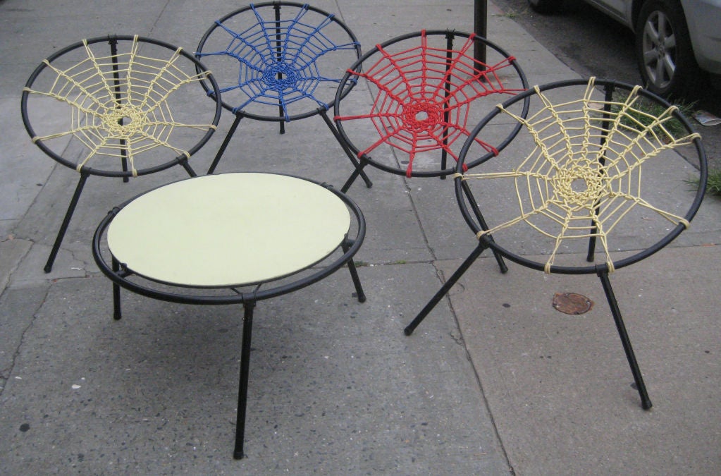 Whimsical and surprisingly comfortable outdoor furniture. Elastic cord is woven into the shape of a spider web on a metal hoop, with collapsible legs. Chairs can be hung for storage.