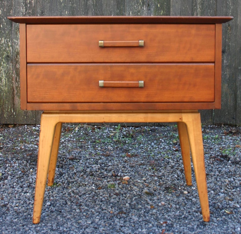 Handsome cherry wood two-drawer nightstand with wood and brass pulls, on walnut legs, by Renzo Rutili for Johnson Brothers and John Stuart. Highboy and dresser also available. 
WE DELIVER TO NYC WEEKLY.