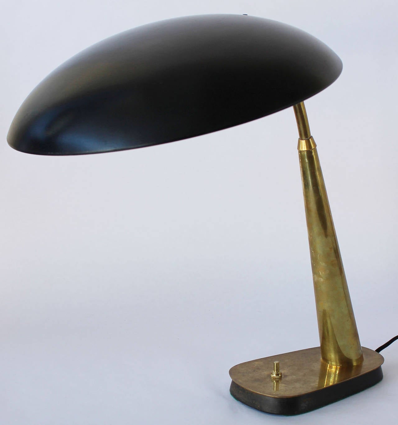A handsome patinated brass and enameled metal desk or task lamp, wired and working.