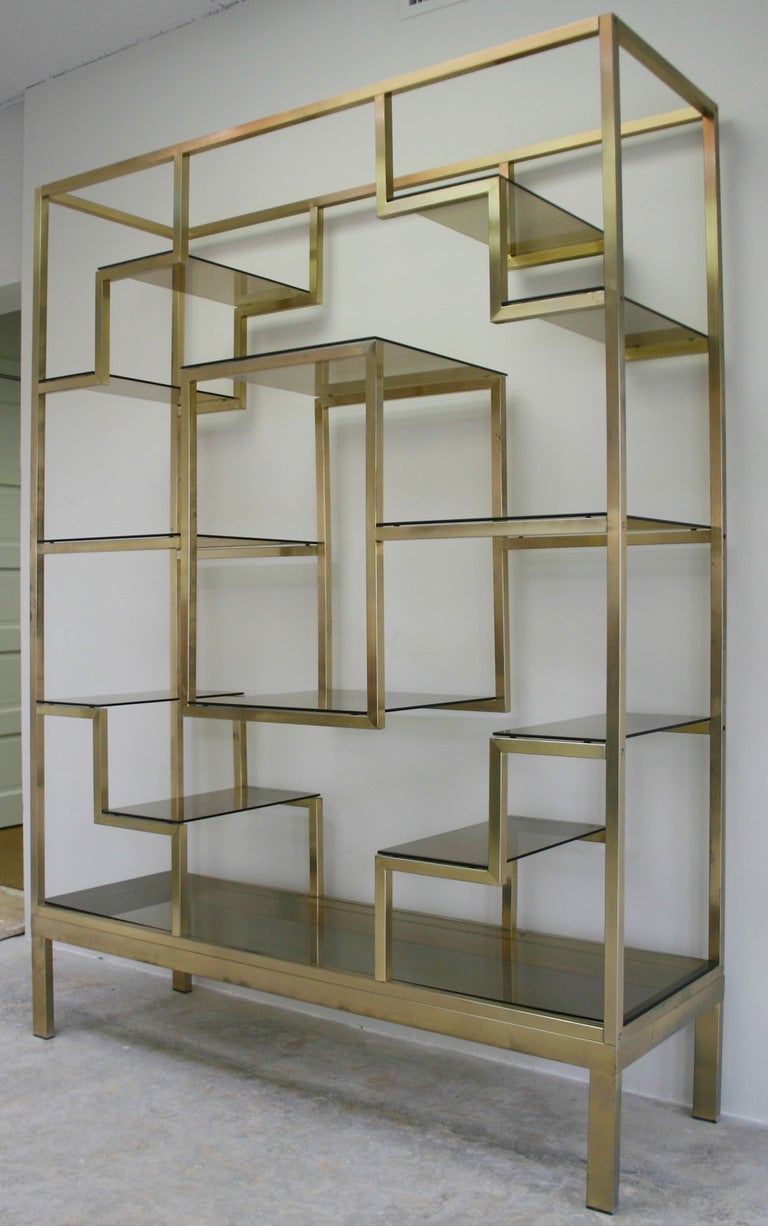 Large, patinaed brass etagere with smoked glass shelves, made in Italy.