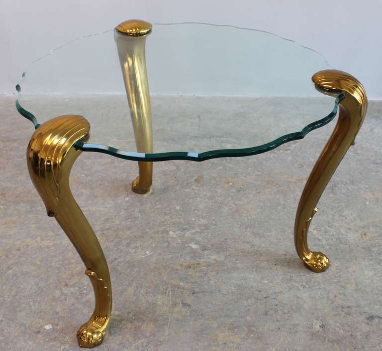 A pair of solid brass regency style tripod end tables with scalloped glass, in the style of Maison Jansen.