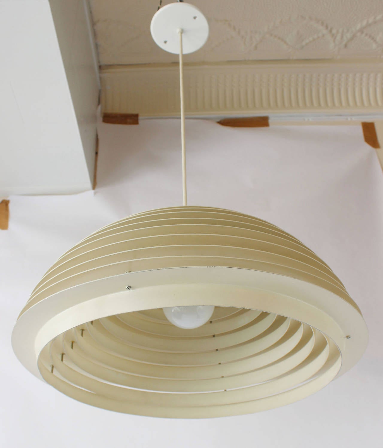 An enameled metal tiered pendant with porcelain socket, by Luminaires Chicago.