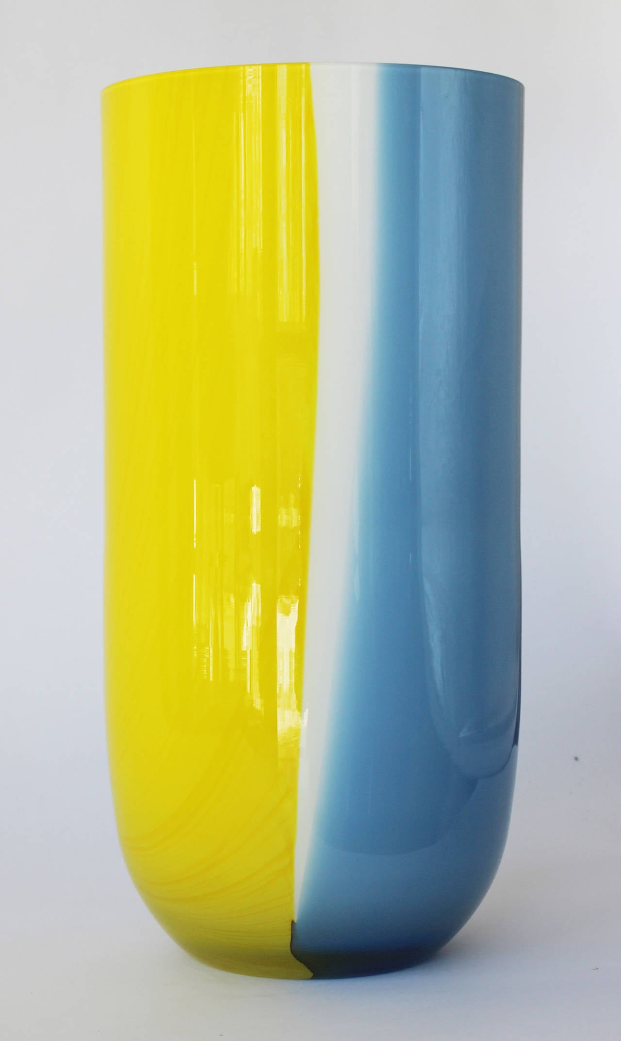 A Vistosi Murano blue, yellow and white cased glass vase with white interior.