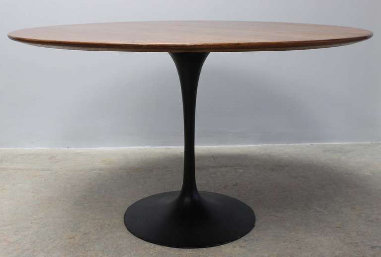 Classic Saarinen tulip dining table with black base walnut top. Five chairs also available.