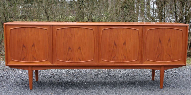 Handsome Scandinavian bookmatch teak sideboard with shelves and drawers, designed by Johannes Andersen.