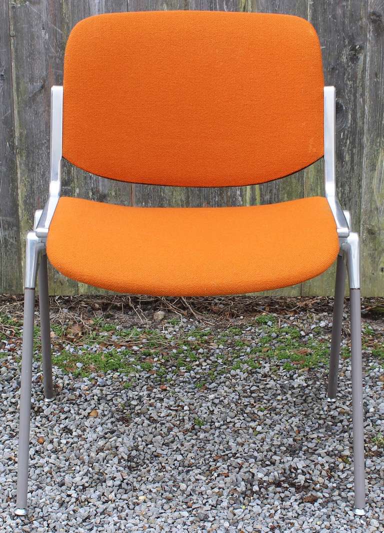 Set of eight dsc 103 stack chairs designed by Giancarlo Piretti for Castelli, in original orange tweed upholstery, with zippers.