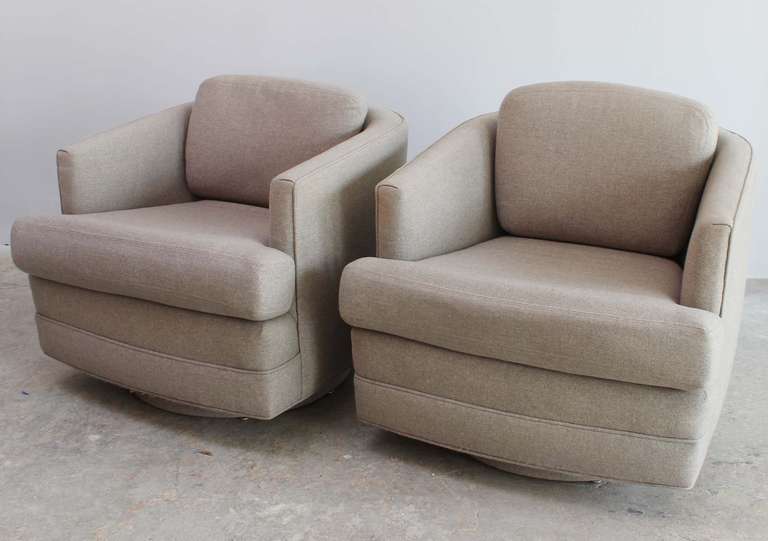 A pair of Milo Baughman style swivel armchairs in original upholstery.