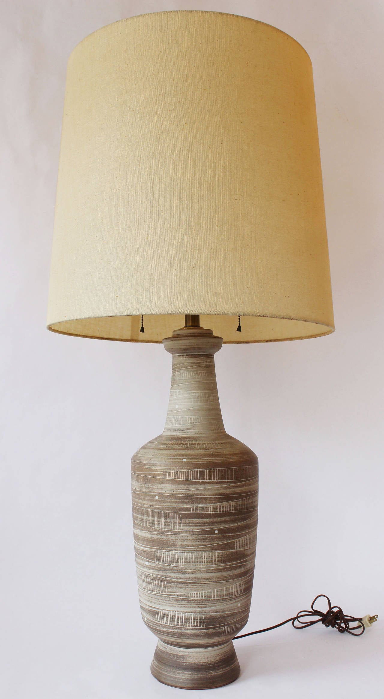 A large Danish ceramic lamp with brown, brushed matte glaze and incised markings. 

Milk glass diffuser and two pull chain sockets. Vintage original shade included.

shade 18