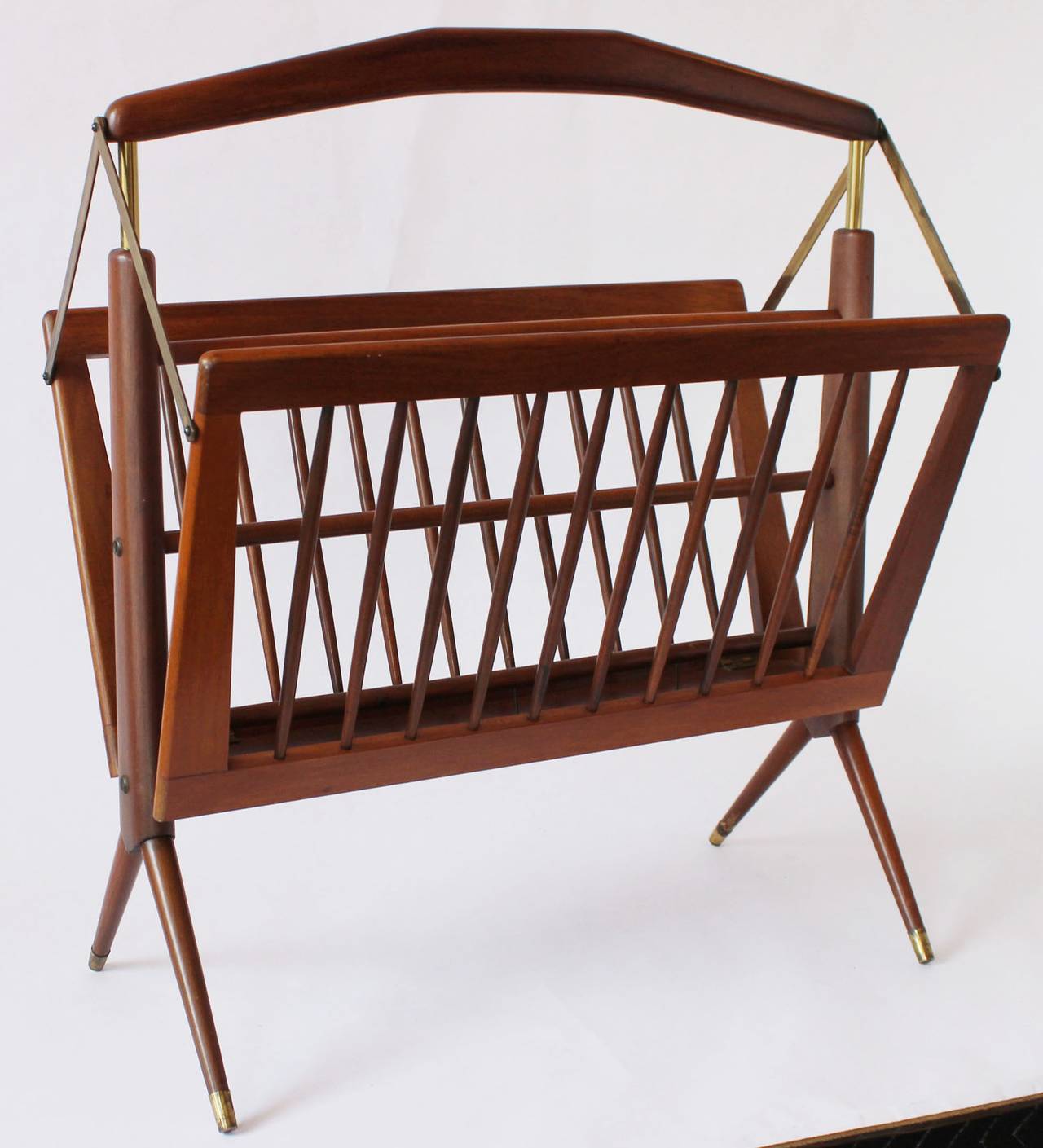 A mid-century walnut and brass folding magazine rack in the manner of Gio Ponti.