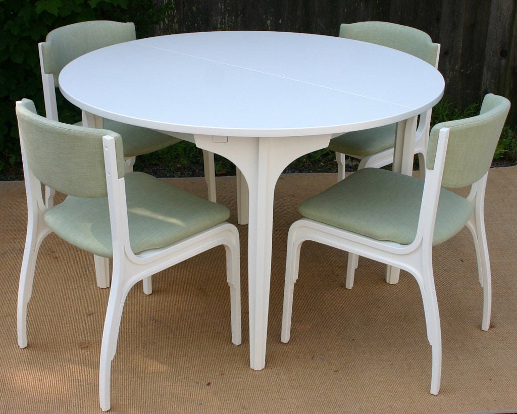 Charming 48 inch round newly white lacquered extendable table and 4 linen-upholstered chairs designed in 1964 by Renato Magri for Cantieri Carugati. Table measures 48