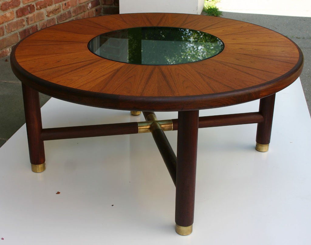 Teak and rosewood round coffee table with smoke glass insert and brass hardware.