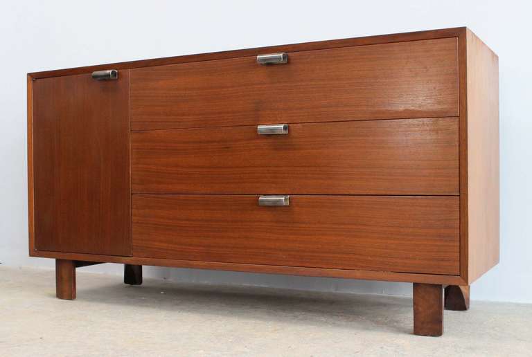 Classic walnut three-drawer dresser with cabinet designed by George Nelson for Herman Miller; labelled. Smaller dresser and cantilever, mirrored vanity also available.