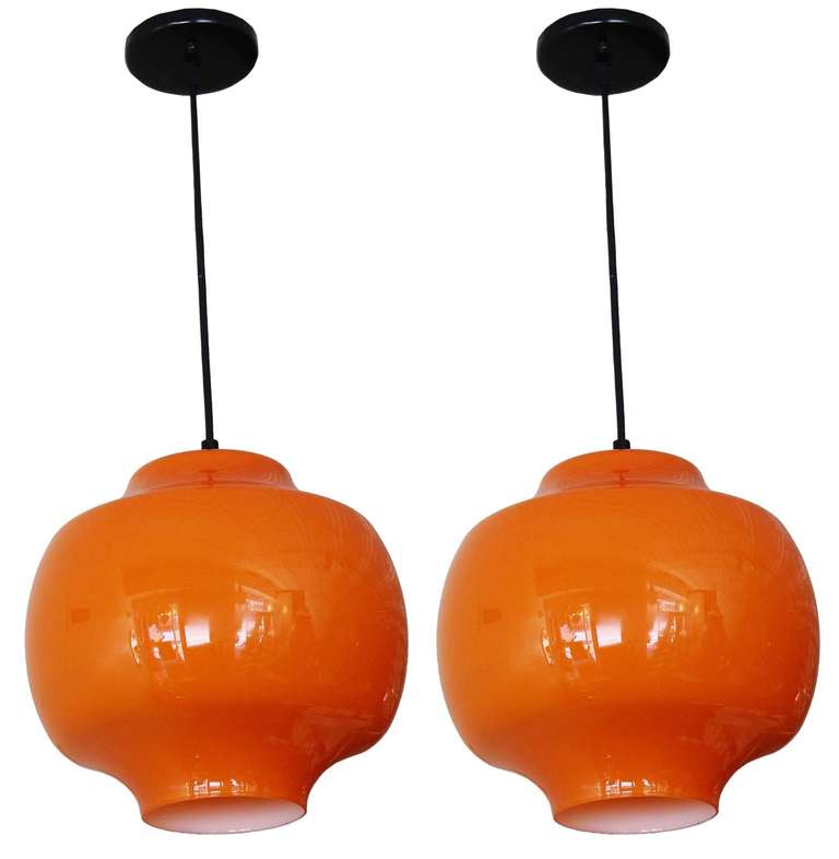 Brilliant Vistosi Murano orange cased glass pendants with white interior and black enameled metal details.

adjustable height cord