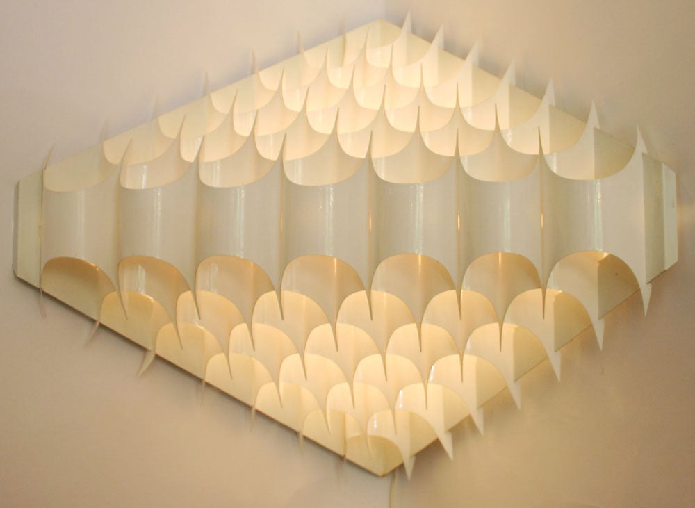 Sculptural corner wall sconces with flexible vinyl-plastic shades and metal backs; by Vest.