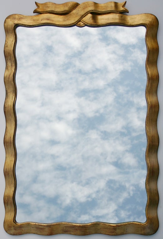 Charming gilded wood ribbon mirror made in Italy.