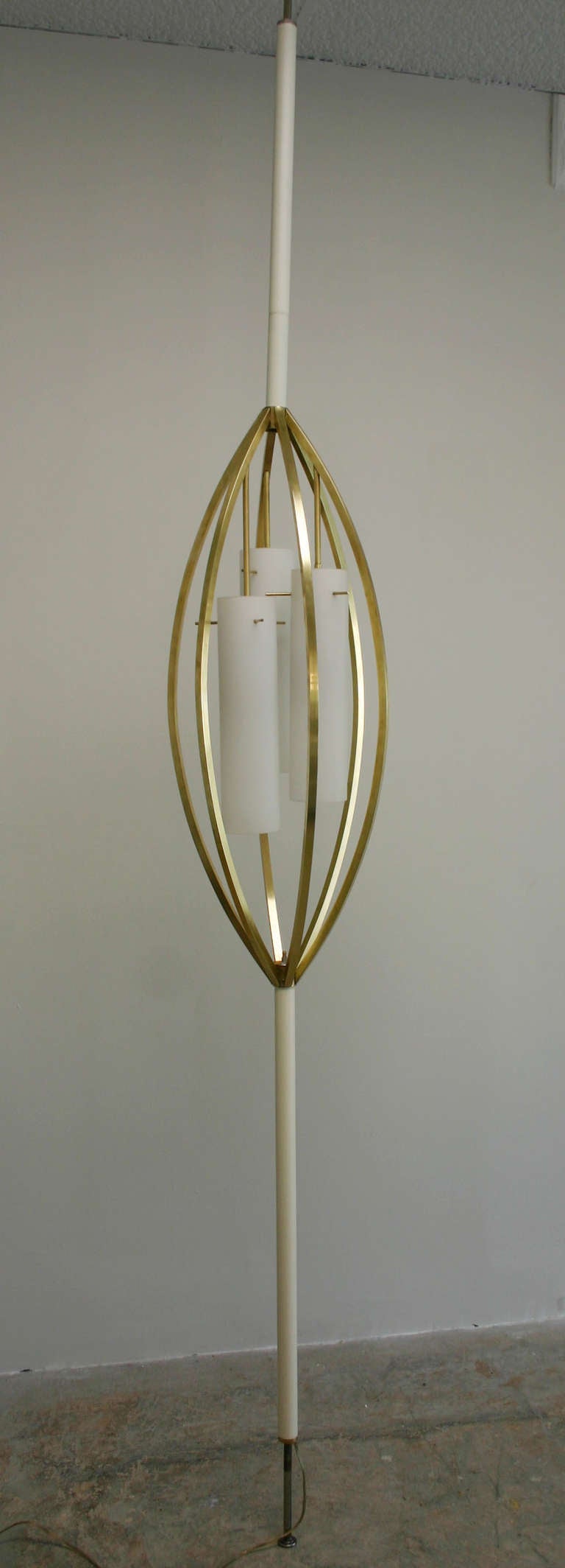 Biomorphic form brass and enameled metal, spring release Italian floor-to-ceiling lamp, with milk glass diffusers.